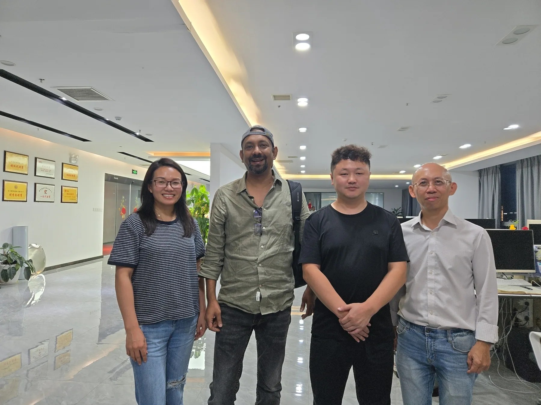 Four people posing together in an office