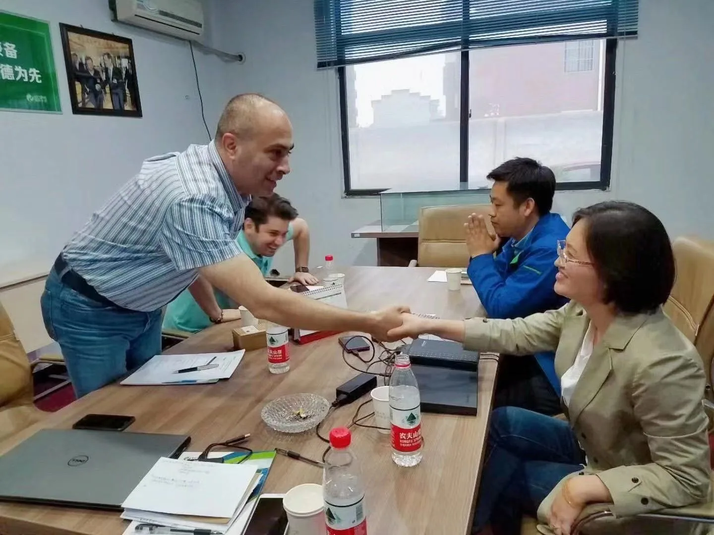People greeting one another at a meeting table