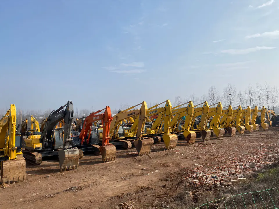 A long row of excavators parked at an equipment yard