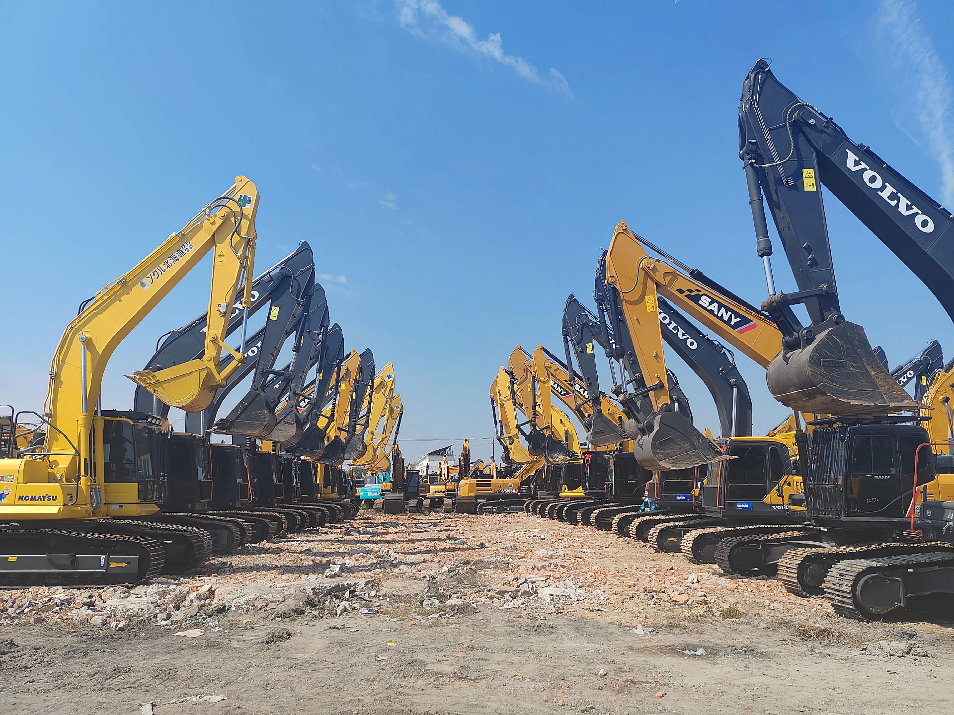 Excavators lined up at a construction equipment yard