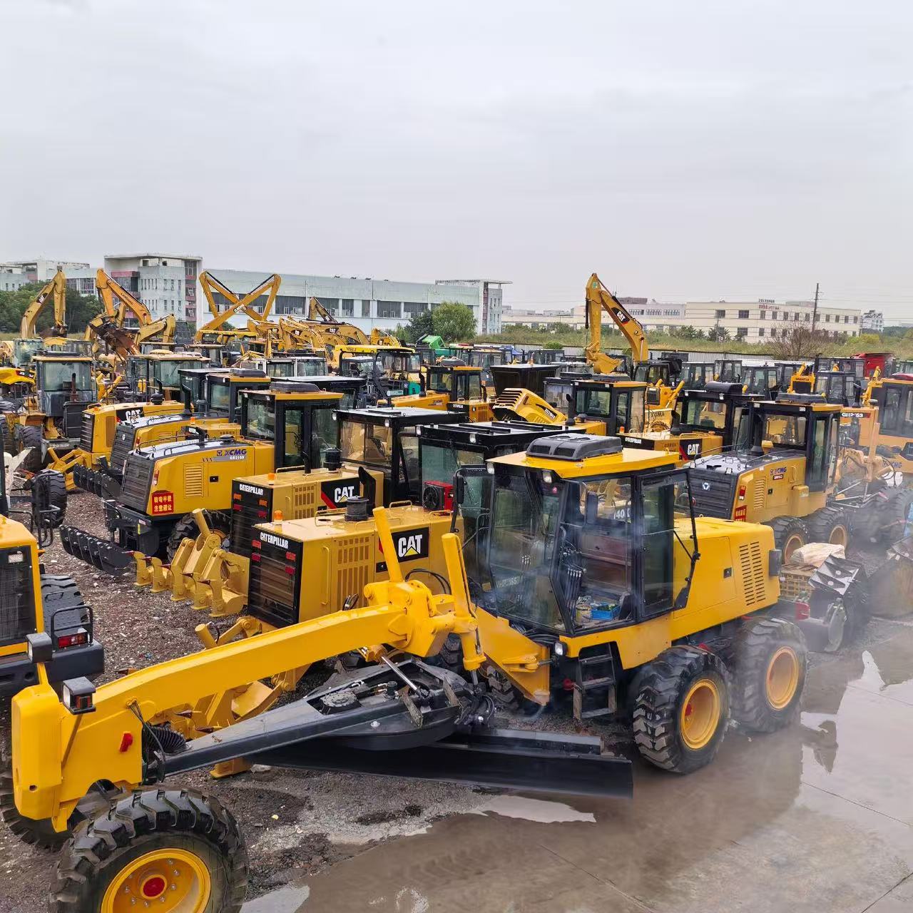 Motor graders and other construction machinery parked in an equipment yard
